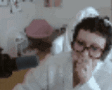 a person wearing glasses and headphones is sitting in front of a computer .