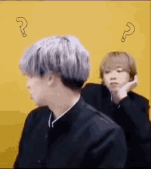 a man with a question mark on his head is standing next to another man .