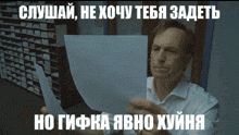 a man in a white shirt is holding a piece of paper with russian writing