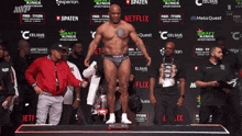 a boxer stands on a scale in front of a wall that says netflix
