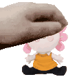 a hand is petting a stuffed doll with pink hair and a yellow shirt .