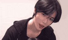 a young man with short black hair is looking at the camera with his mouth open .