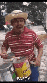 a man in a cowboy hat is holding a can of paint and a brush .