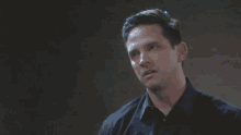 a man in a black shirt looks to the side