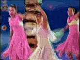 a group of girls in pink dresses are dancing in front of a treasure chest