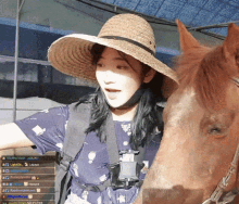 a woman wearing a straw hat stands next to a horse