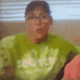 a blurry picture of a woman wearing a green shirt that says get stuff
