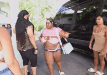 a woman in a bikini is walking towards a man in a black shirt