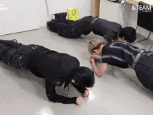 a group of men doing push ups in a room that says & team