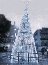 a large white christmas tree with a pink star on top