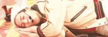 a man wearing a jacket and a hat is laying down with his head on his hands