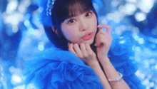 a girl in a blue dress is making a face