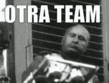 a black and white photo of a man holding a gun with the words otra team written above him