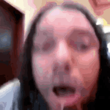 a blurry picture of a woman 's face with a slight smirk on her face
