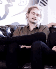 a man is sitting on a couch with his feet up