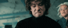a man with curly hair is making a face while a woman looks on