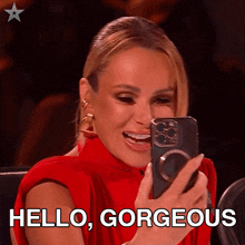 a woman in a red dress is taking a picture of herself with her phone and the words hello gorgeous are written below her