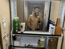 a man taking a picture of himself in a bathroom mirror with a bottle of shaving foam in the background
