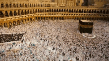 a large crowd of people are gathered in front of a mosque