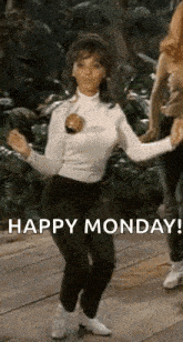 a woman is dancing on a wooden floor with a happy monday message .