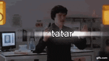 a man standing in front of a computer with the word tatar written on the screen