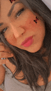 a close up of a woman 's face with butterflies on it
