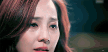 a close up of a woman 's face with tears coming out of her eyes