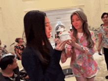 a woman blows out candles on a small cake in front of a sign that says ford dog