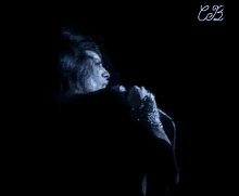a man is singing into a microphone on a stage .
