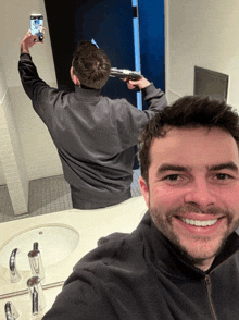 a man taking a picture of himself with a gun in front of a mirror