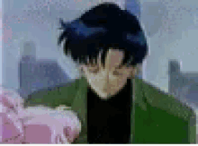 a man in a green jacket is holding a pink object in his hand .