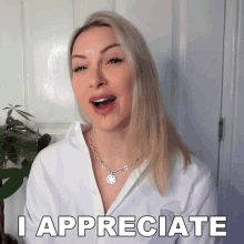 a blonde woman says i appreciate in front of a plant