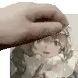 a hand is holding a piece of paper with a picture of a girl .