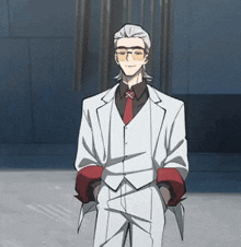 a man in a white suit with a red tie