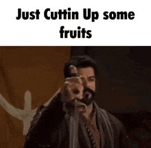 a man with a beard is holding a piece of paper that says just cuttin up some fruits .
