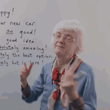 an elderly woman stands in front of a whiteboard that says " happy "