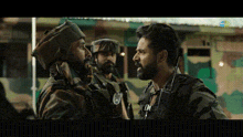 two soldiers are talking to each other in front of a building