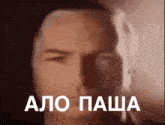 a close up of a man 's face with the words " alo pasha " written in white