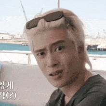 a man with blonde hair wearing sunglasses is making a funny face