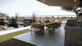 a patio with a table and chairs and a waterfall in the background