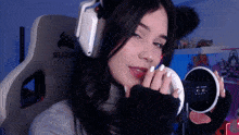 a woman wearing a pair of corsair headphones sits in a gaming chair