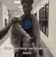 a man in a fur coat is standing in a hallway with another man .