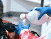 a person wearing blue gloves is holding a bottle of alcohol