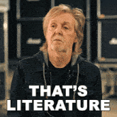 a man with a beard is standing in front of a sign that reads that 's literature