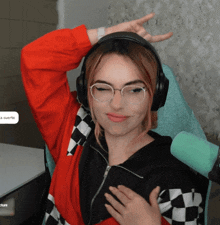 a woman wearing glasses and headphones is sitting in a chair