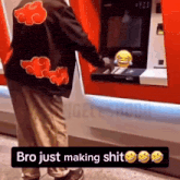 a man wearing a jacket with clouds on it is taking money out of an atm .