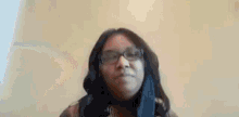 a woman wearing glasses and a scarf is making a funny face .