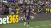 a soccer player is jumping in the air in front of a bet365 advertisement