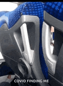 a blue seat on a bus with the words covid finding me written on it .