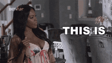 a woman in a bra is standing in a living room and saying this is .